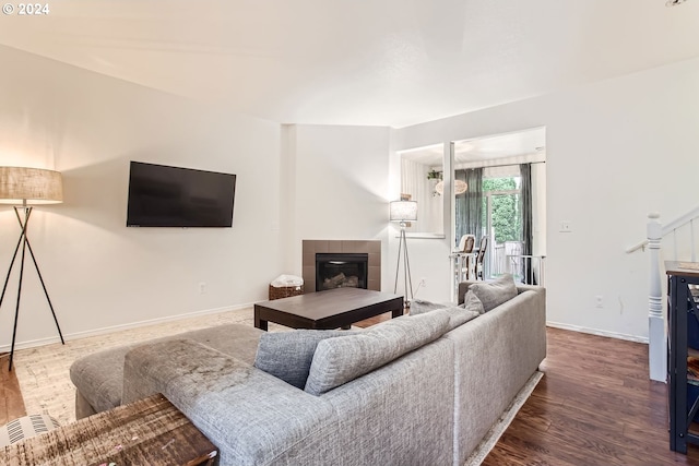 living room with dark hardwood / wood-style floors and a tile fireplace