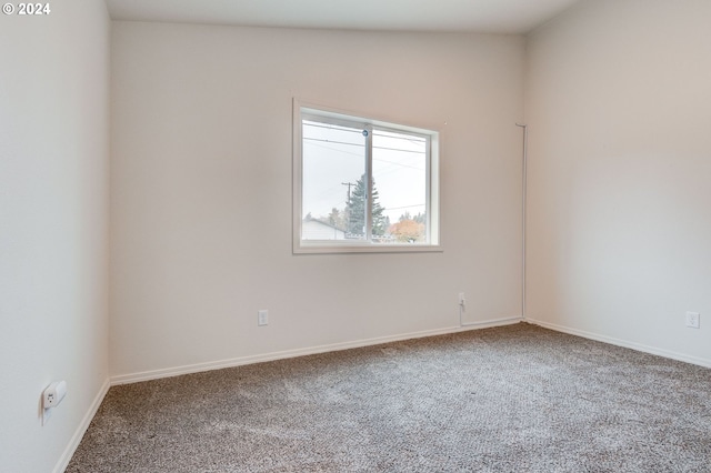 carpeted empty room with vaulted ceiling