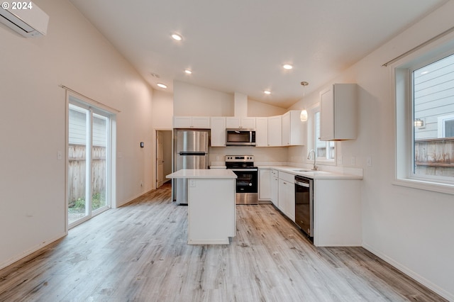 kitchen featuring light wood-type flooring, stainless steel appliances, vaulted ceiling, and hanging light fixtures