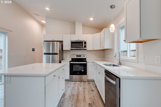 kitchen with stainless steel appliances, white cabinetry, lofted ceiling, and sink