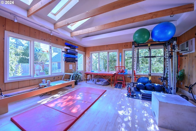 interior space featuring vaulted ceiling with skylight and a wall unit AC