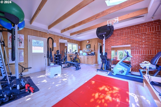 workout room featuring brick wall, hardwood / wood-style floors, and wooden walls