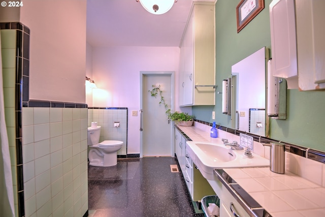 bathroom with tile walls, vanity, and toilet