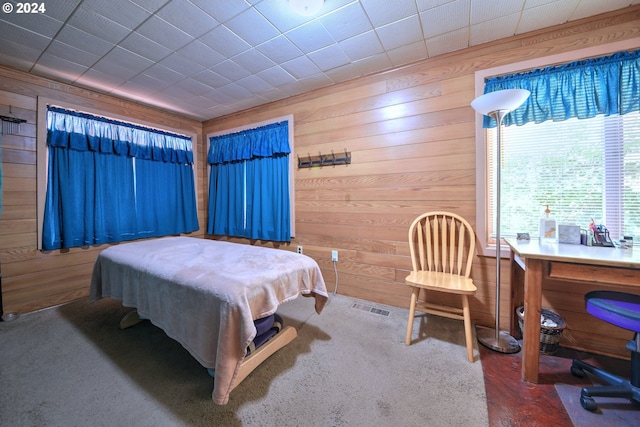 bedroom with carpet floors and wood walls