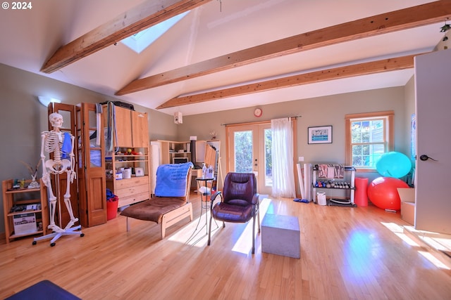 living room with french doors, vaulted ceiling with skylight, and light wood-type flooring