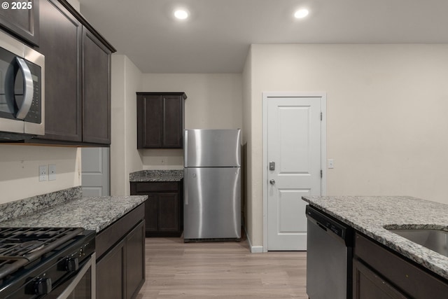 59 NE 134th Pl, Portland, OR 97230 - kitchen with appliances with stainless steel finishes, light wood-style floors, light stone counters, dark brown cabinets, and recessed lighting
