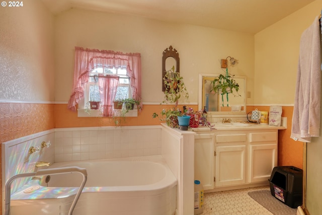 bathroom featuring vanity, vaulted ceiling, and a bathing tub