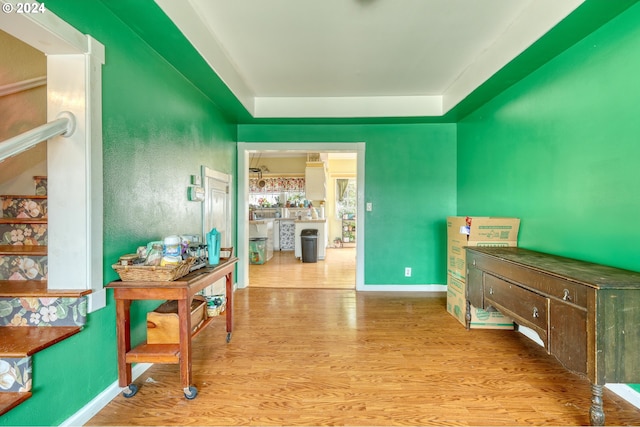 interior space with a tray ceiling and light hardwood / wood-style flooring