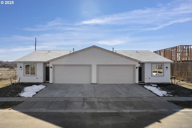 ranch-style home featuring an attached garage, driveway, and a shingled roof