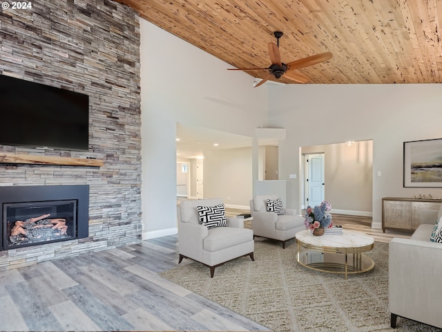 unfurnished living room with a stone fireplace, light hardwood / wood-style floors, wooden ceiling, and high vaulted ceiling