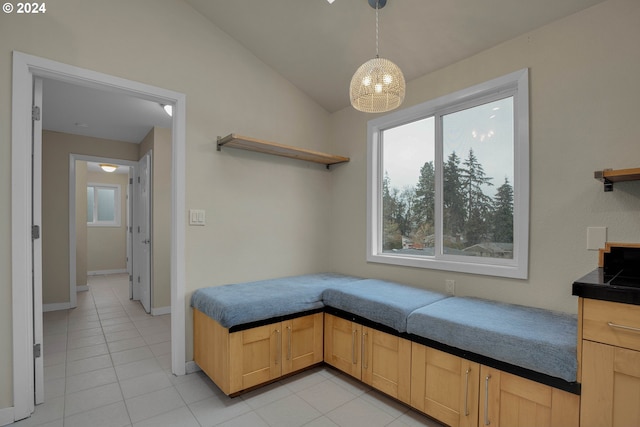 bedroom with lofted ceiling, a notable chandelier, light tile patterned floors, and multiple windows