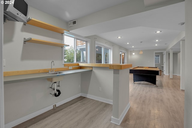 kitchen with pool table, kitchen peninsula, light hardwood / wood-style floors, a kitchen breakfast bar, and sink