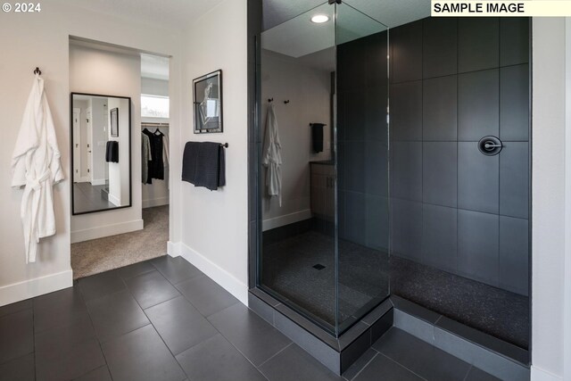 bathroom featuring tile patterned flooring and a shower with shower door