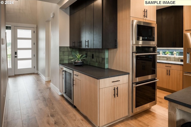 kitchen with double oven, wine cooler, light hardwood / wood-style flooring, and tasteful backsplash