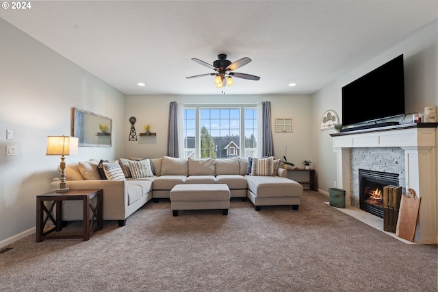 carpeted living room with ceiling fan, a textured ceiling, and a fireplace