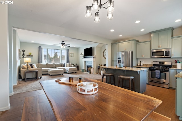 6905 Flicker Dr SE, Salem, OR 97306 - dining area with a warm lit fireplace, recessed lighting, dark wood-type flooring, a ceiling fan, and baseboards