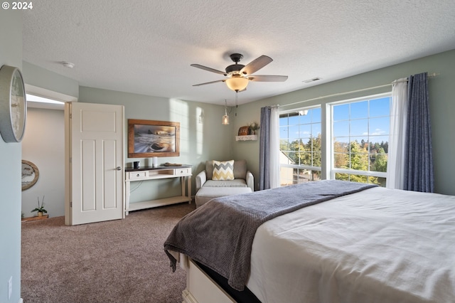 carpeted bedroom featuring ceiling fan and a textured ceiling