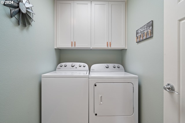 washroom featuring washer and dryer and cabinets