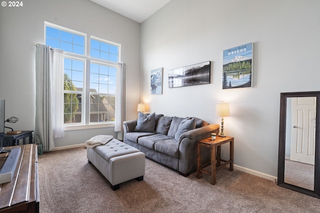 carpeted living room featuring high vaulted ceiling