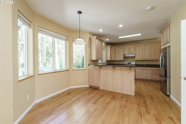 kitchen featuring stainless steel fridge, hanging light fixtures, kitchen peninsula, light wood-type flooring, and light brown cabinetry