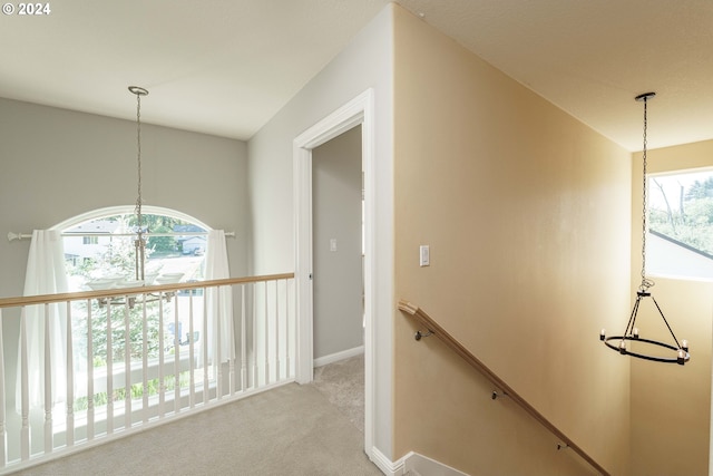 hallway featuring light colored carpet