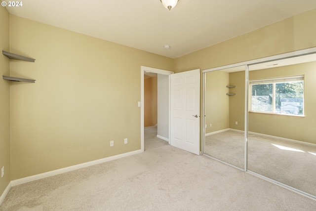 unfurnished bedroom featuring light carpet and a closet