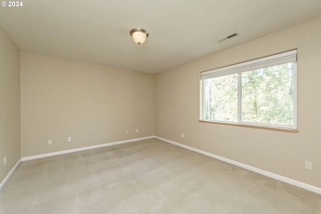 carpeted spare room featuring a textured ceiling