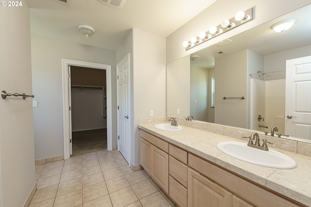 bathroom featuring vanity, a textured ceiling, and tile patterned floors