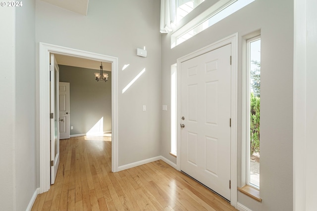 entryway with light hardwood / wood-style flooring and a chandelier