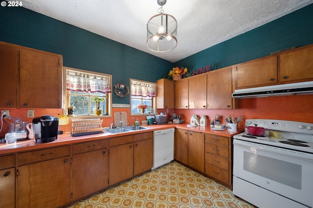 kitchen featuring decorative light fixtures, white appliances, sink, and a textured ceiling