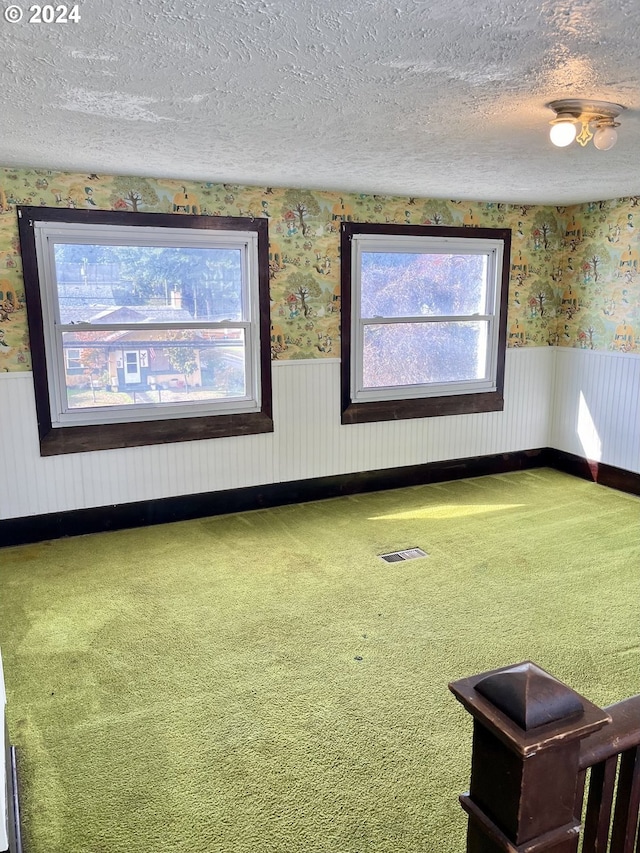 interior space featuring golf simulator, carpet floors, and a textured ceiling