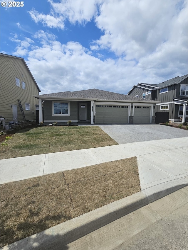 3815 S Arwana Ln, Ridgefield, WA 98642 - view of front of property with an attached garage, driveway, a shingled roof, and a front yard