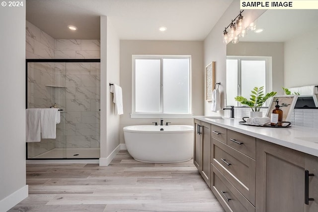 bathroom featuring shower with separate bathtub, vanity, and hardwood / wood-style flooring