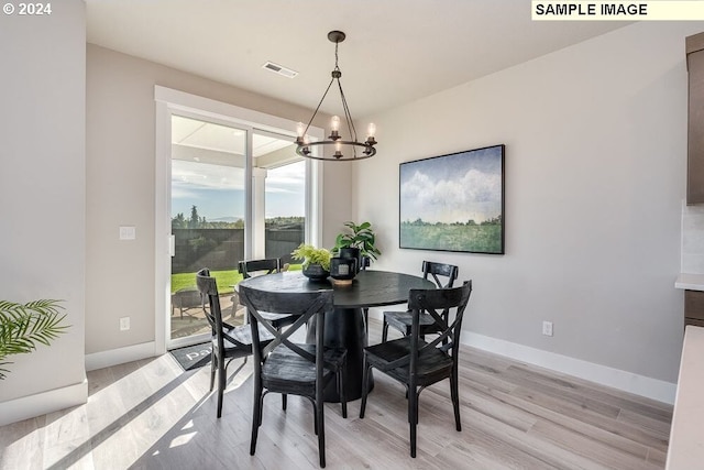 dining area featuring a notable chandelier and light hardwood / wood-style flooring