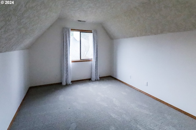 bonus room featuring carpet flooring, a textured ceiling, and vaulted ceiling