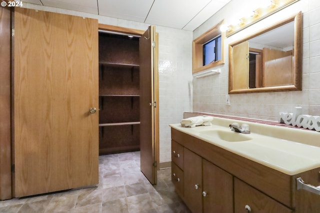 bathroom with vanity and tile walls