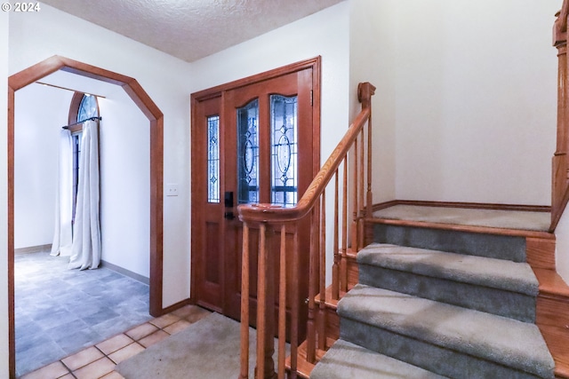 foyer entrance with a textured ceiling