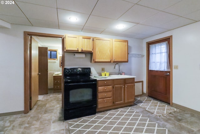 kitchen with black stove, a paneled ceiling, and sink