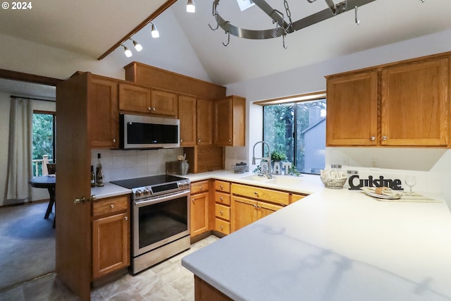 kitchen with appliances with stainless steel finishes, backsplash, plenty of natural light, and sink