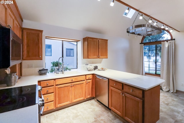 kitchen featuring kitchen peninsula, a skylight, stainless steel appliances, sink, and a notable chandelier