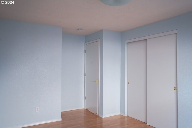 unfurnished bedroom featuring a closet and light wood-type flooring