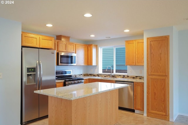 kitchen featuring light stone countertops, sink, a center island, and appliances with stainless steel finishes