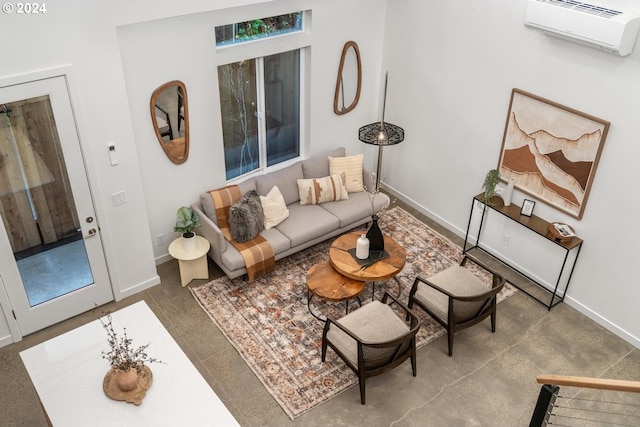 living room featuring a wall unit AC and concrete floors