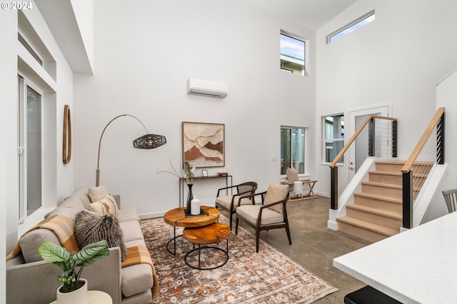 living room featuring a high ceiling and a wall mounted air conditioner