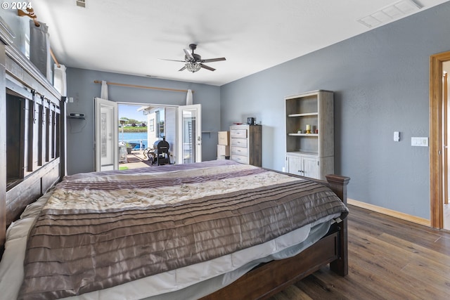 bedroom featuring access to outside, a water view, ceiling fan, and dark hardwood / wood-style floors