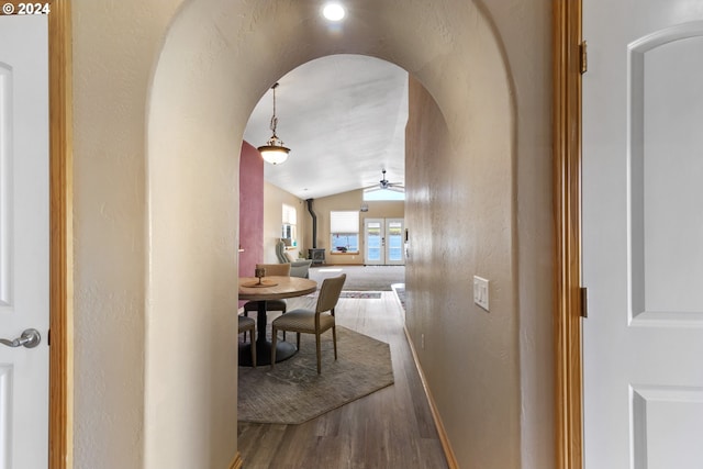 corridor with lofted ceiling and hardwood / wood-style flooring