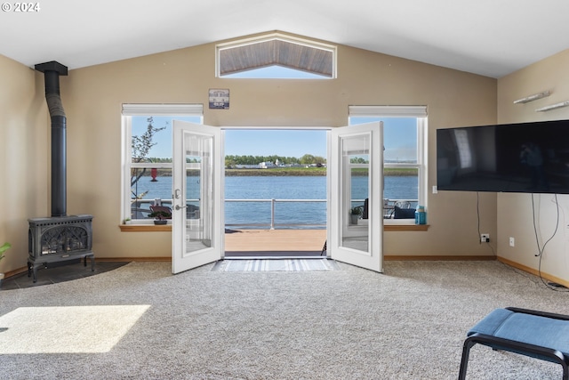 carpeted living room featuring lofted ceiling, a wood stove, and french doors