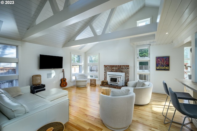 living room featuring a healthy amount of sunlight, light hardwood / wood-style floors, and high vaulted ceiling