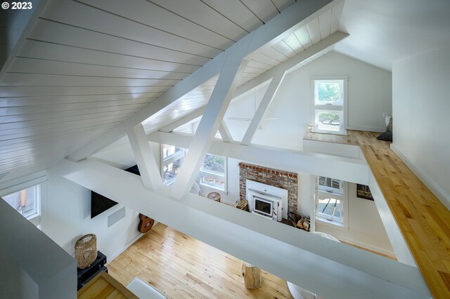 living room featuring hardwood / wood-style floors, lofted ceiling with beams, and a fireplace