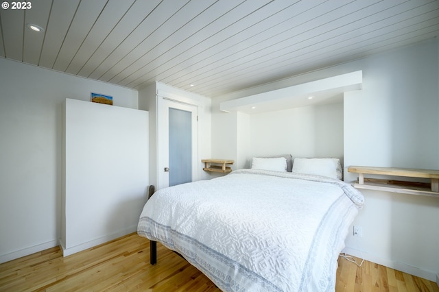 bedroom with light hardwood / wood-style flooring and wood ceiling